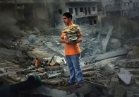 A boy saves a few books from the rubble of his home, a six storey apartment building which was bombed by the Israeli air force. The building was in the middle of a densely populated area in the city of Tyre. Three casualties were reported.