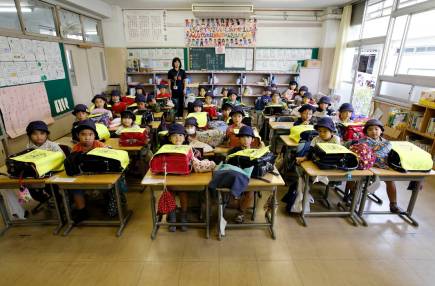 First grade students and their class teacher Teruko Takakusaki (in background) pose for a photo during their homeroom period at the end of the school day at Takinogawa Elementary School in Tokyo, Japan. (Toru Hanai/Reuters)