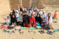 Teacher Mahajera Armani and her class of girls pose for a picture at their study open area, founded by Bangladesh Rural Advancement Committee (BRAC), outside Jalalabad city, Afghanistan. (Parwiz/Reuters)